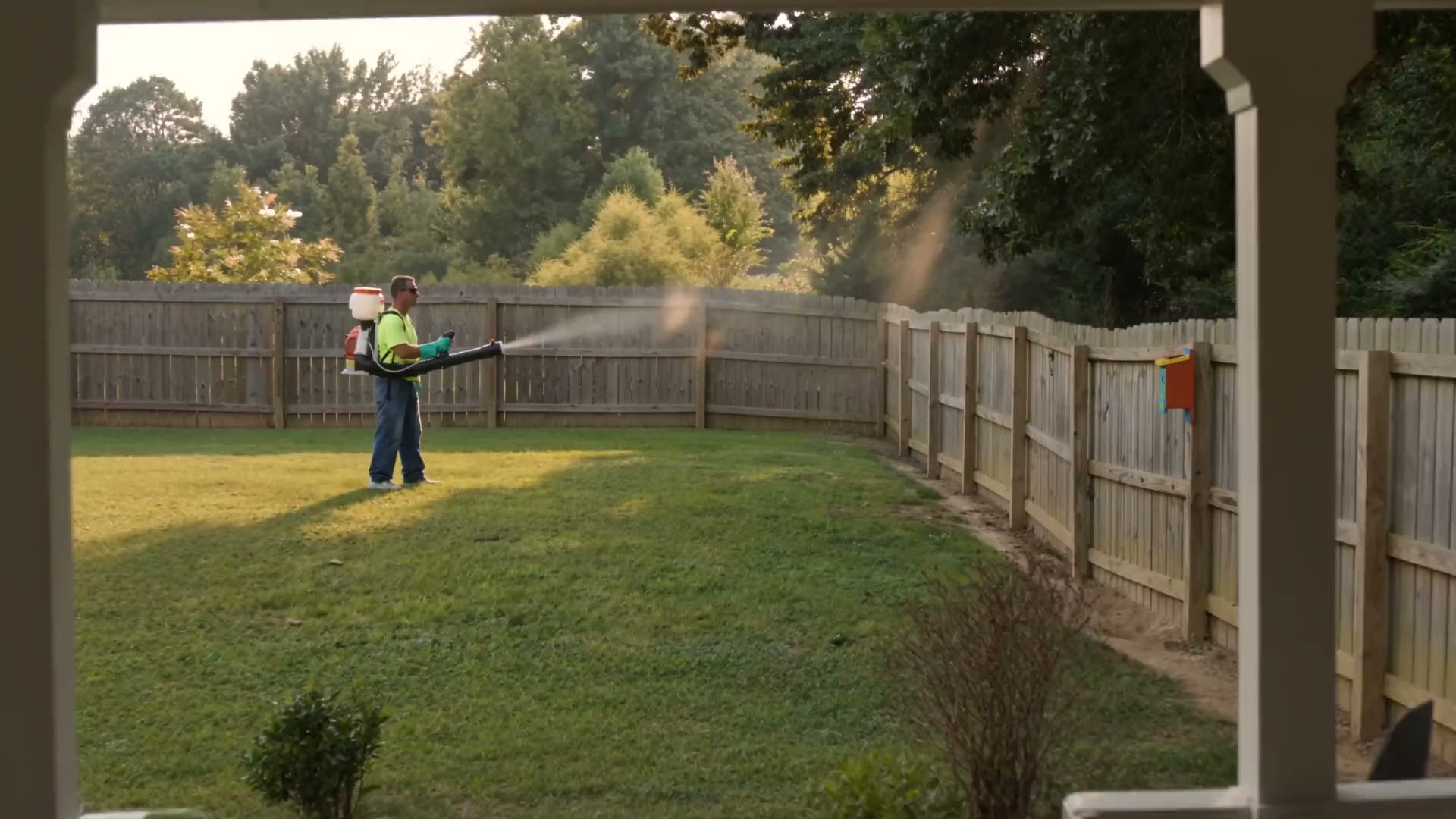 A technician working the mosquito barrier along the back fence of a northern Alabama garden